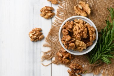 Ahşap arka planda Walnut 'ın beyaz bardaktaki üst görüntüsü. Sağlıklı fındık. Ceviz harika bir antioksidan kaynağıdır. LDL kolesterolü de buna dahildir. Bu da atherosclerosis 'i teşvik eder..