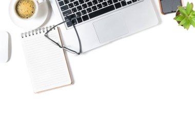 Beyaz ofis masası, dizüstü bilgisayarlı boş defter ve sade kahve. Boşluğu kopyalayan, düzleştiren ve kopyalayan üst görünüm