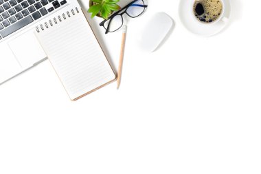 Beyaz ofis masası, dizüstü bilgisayarlı boş defter ve sıcak kahve. Boşluğu kopyalayan, düzleştiren ve kopyalayan üst görünüm