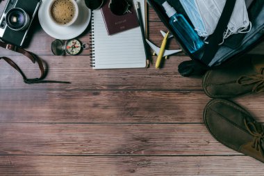 Maske ve alkol spreyini valizin yanına koyun. Klasik kamera, defter, tahta ve fotokopi alanı haritası. seyahat ve covid 19 konseptini önlemek