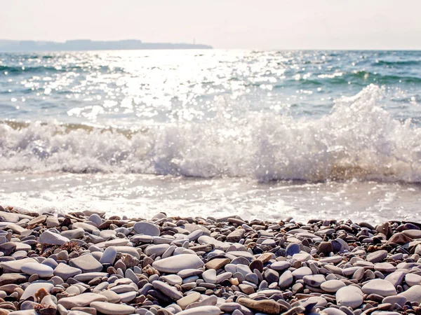 Deniz dalgalarına karşı çakıl taşı plajı