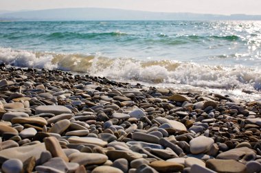 Deniz dalgalarına karşı çakıl taşı plajı
