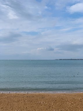 Deniz, kum ve bulutlu gökyüzü