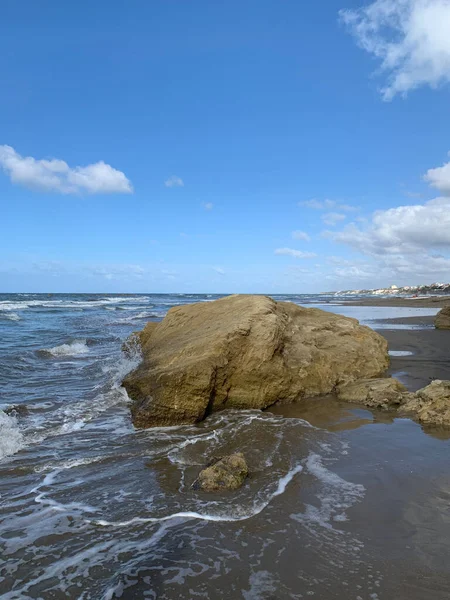 波に囲まれた海岸沿いの大きな岩 — ストック写真