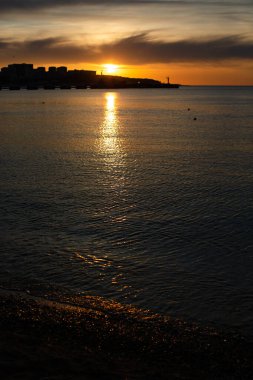 Gün batımında suya bir güneş ışığı yansıyor.