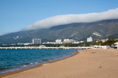 Şehirde boş bir sahil, dağların arka planına karşı.