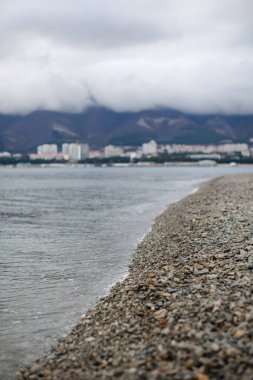 Dağların arkasındaki çakıl taşı plajı.