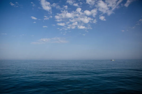 Mavi deniz ve uzakta bir tekne.