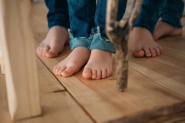 Ailenin ayakları, ahşap zeminde kot pantolon içinde..