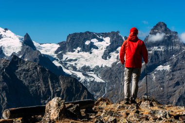 Kafkasya 'da seyahat eden bir adam. Dağ sporları. Sporcu mutlu son. Dağ turizmi. Yürüyüş turu. Dağlara yolculuk. Dağların arasında yürüyen İskandinav. Boşluğu kopyala