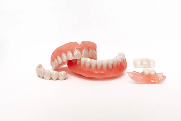 Beyaz arka planda takma dişler. Takma dişlerin yakın plan çekimi. Çenenin tamamen çıkarılabilir plastik protezi. Protez dişçilik. Takma diş. Plastik takma dişlerin yakın plan çekimlerinde hoş bir arkaplan yok.