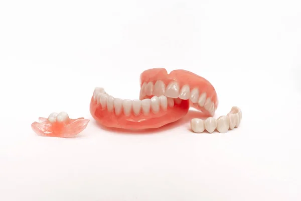 Beyaz arka planda takma dişler. Takma dişlerin yakın plan çekimi. Çenenin tamamen çıkarılabilir plastik protezi. Protez dişçilik. Takma diş. Plastik takma dişlerin yakın plan çekimlerinde hoş bir arkaplan yok.