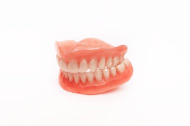 Full removable plastic denture of the jaws. Set of dentures on a white background. A side view of a dental prosthesis, isolate. Two acrylic dentures. Dentures or false teeth, close-up. Copy space clipart
