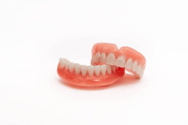 Çenenin tamamen çıkarılabilir plastik protezi. Beyaz arka planda takma dişler. İki akrilik takma diş. Üst ve alt çeneler ve takma dişler. Takma dişler ya da takma dişler, yakın plan. Boşluğu kopyala