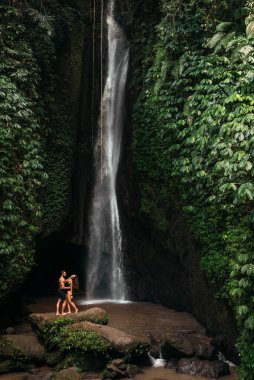 Şelalede aşık bir çift. Balayı gezisi. Bali adasında mutlu bir çift. Güzel bir çift dünyayı gezer. Endonezya 'ya seyahat. Tatildeki mutlu çift. Düğün gezisi. Boşluğu kopyala