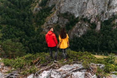 Birbirine aşık bir çift güzel manzaraya, dikiz aynasına hayran. Bir adam ve bir kadın kayanın üzerinde. Birbirine aşık çiftler seyahat eder. Dağlarda bir yürüyüş. Dağlarda seyahat eden bir çift. Yürüyüş