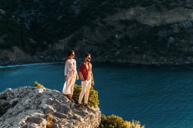 Bir adam, deniz kıyısında güzel bir kadını kucaklıyor. Mutlu bir çift deniz kenarında şafakla tanışır. Çift deniz kenarında eğleniyor. Denizde güzel bir çift. Boşluğu kopyala