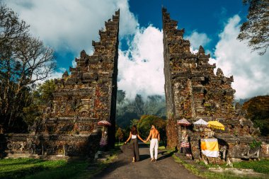 Bali tapınağındaki güzel çift. Endonezya 'da seyahat eden kadın ve erkek. Bali kapısındaki çift. Çift dünyayı geziyor. Asya 'daki turistik yerlere seyahat et. Bali 'de turistler. Boşluğu kopyala.
