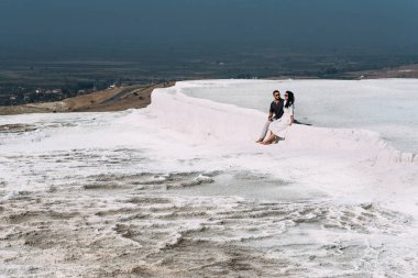 Türkiye 'de aşık bir çift, Pamukkale. Aşık şık bir çift. Yeni evli bir çift. Jeotermal menfezlerde mutlu çift. Gün batımında aşıklar. Pamukkale, Türkiye 'de jeotermal kaynaklara sahip bir bölge.