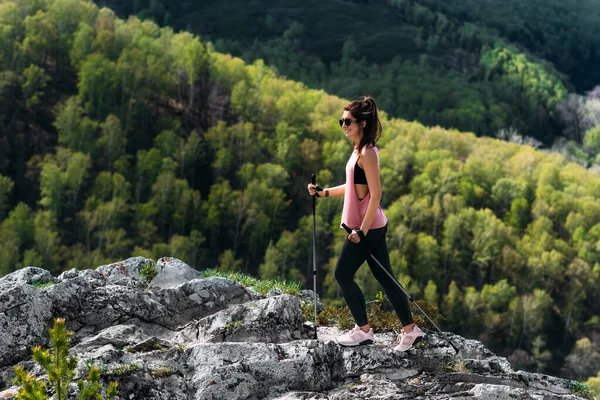 山の中でハイキング 男は山の中をノルディックウォーキングに従事している 山の中で観光客 若い女性が山の中でノルディックな散歩をしていた アクティブなレジャータイムコンセプト スペースのコピー — ストック写真