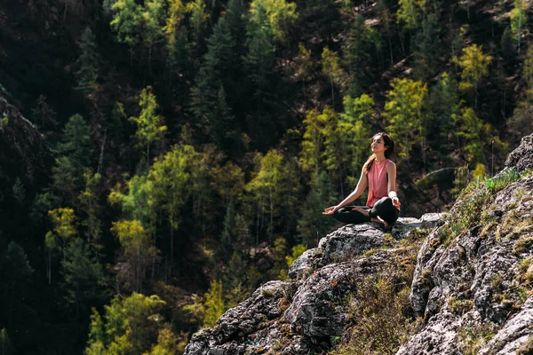 ヨガをする魅力的な女性 健康的なライフスタイル 山の中でヨガをする女性 日の出にヨガをする女の子 女性は自然に瞑想します 山の中で瞑想 スペースのコピー — ストック写真