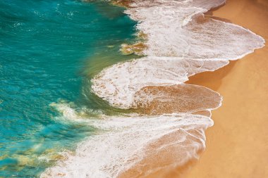 Güzel kumlu sahil. Turkuaz okyanus dalgaları ve güzel kumlu plajların hava panoramik drone görüntüsü. Kumsalın havadan görünüşü. Su sıçratan dalgalar ve kumsal kum konseptiyle güzel, parlak deniz.