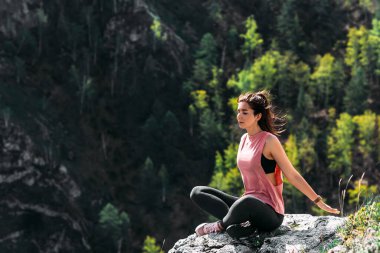 Çekici ve sağlıklı genç bir kadın şafakta dağlarda yoga yapıyor. Yoga temiz havada. Yoga egzersizi yapan mutlu bir kadın. Doğada meditasyon. Dağlarda yoga yapan bir kadın.