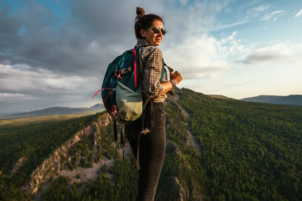 山の中で女性旅行者の肖像画 ハイキングのコンセプト 幸せな女性は山の中でハイキング中に日光を楽しんでいます 旅行者はカメラを見る スペースのコピー — ストック写真