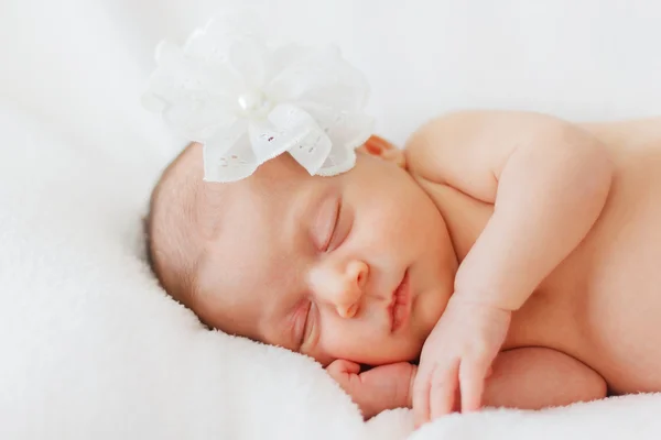 Close up felice neonata dormire con fiore bianco — Foto Stock