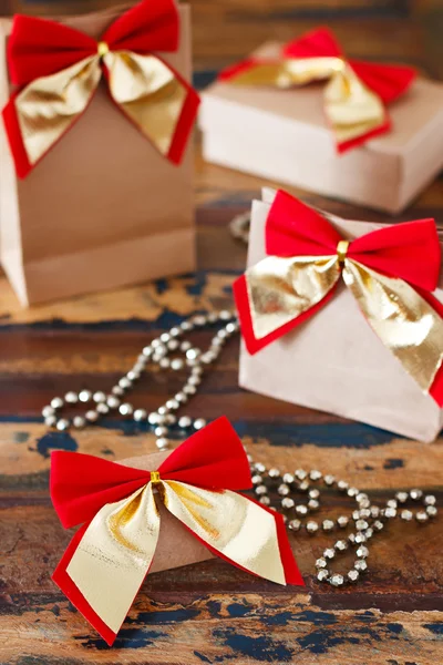 Paquete de papel de regalo de Navidad con lazo rojo dorado —  Fotos de Stock