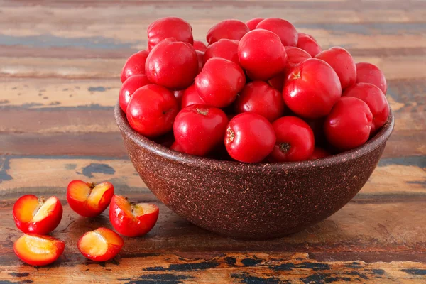 Malpighia glabra (červená acerola), tropické ovoce na dřevěný stůl — Stock fotografie