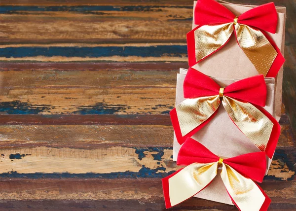 Paquete de papel de regalo de Navidad con lazo rojo dorado —  Fotos de Stock