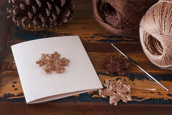 Tarjeta de felicitaciones hechas a mano de Navidad con copos de nieve de ganchillo marrón —  Fotos de Stock