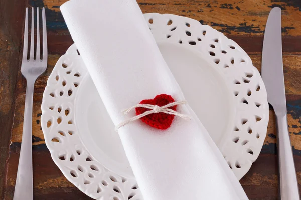 Decorazione San Valentino: Piatto bianco coltello forchetta serviette con cuore crochet rosso fatto a mano — Foto Stock