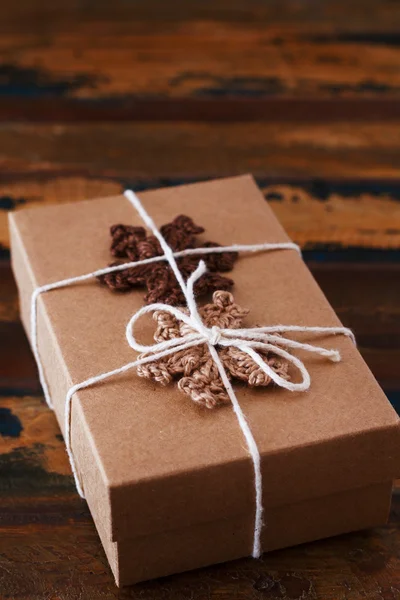 Caja de regalo de Navidad con copos de nieve hechos a mano de ganchillo marrón —  Fotos de Stock