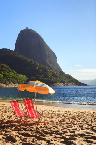 Dağ Sugarloaf güneş şemsiyesi ve kırmızı Beach (Praia sandalyeler