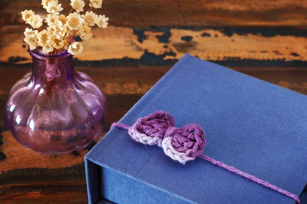 Handgemachte bunte Häkelschleife für Geschenkverpackung mit Vase auf dem Tisch — Stockfoto