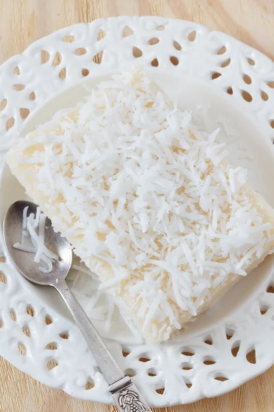 Солодкий кус-кус-пудинг (cuscuz doce) кокос на білій тарілці — стокове фото
