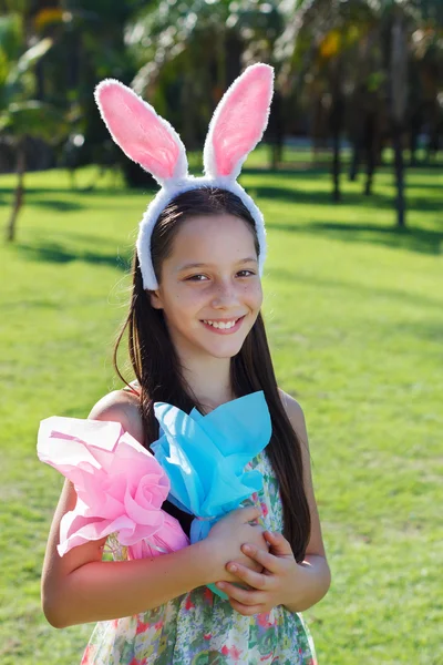 Smiling teen girl with rabbit ears holding Easter chocolate eggs — Stock Photo, Image