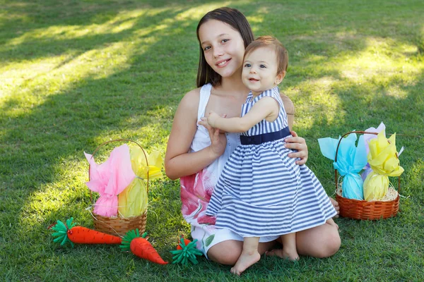 Duas meninas sorridentes irmãs bebê e adolescente com ovos de chocolate para — Fotografia de Stock