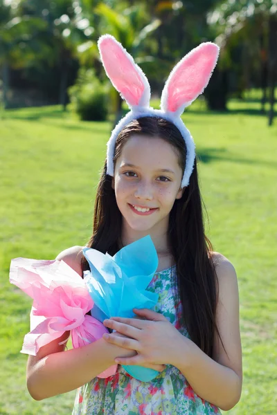 Smiling happy teen girl with rabbit ears and Easter chocolate eg — Stock Photo, Image