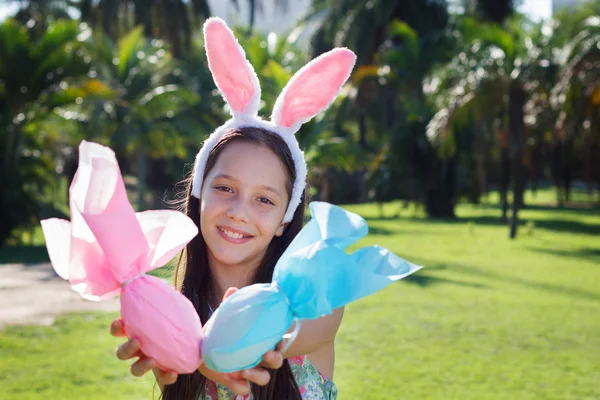 Smiling cute teen girl with rabbit ears holding Easter chocolate — Stock Photo, Image