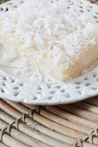 Солодкий кус-кус-пудинг з кокосовим горіхом на білій старовинній тарілці на во — стокове фото