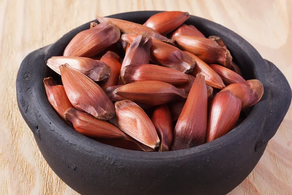 Close-up van pinhao - Braziliaanse pine op zwarte pot op houten tafel — Stockfoto