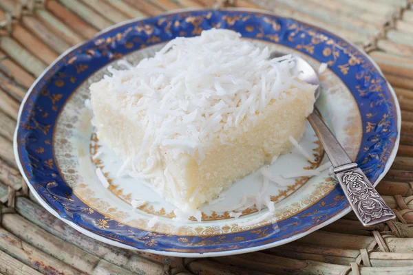 Rice pudding with coconut on blue vintage plate with spoon — Stock Photo, Image