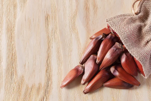 Pinhao - brazilian pine in sackcloth bag on wooden table — Stock Photo, Image