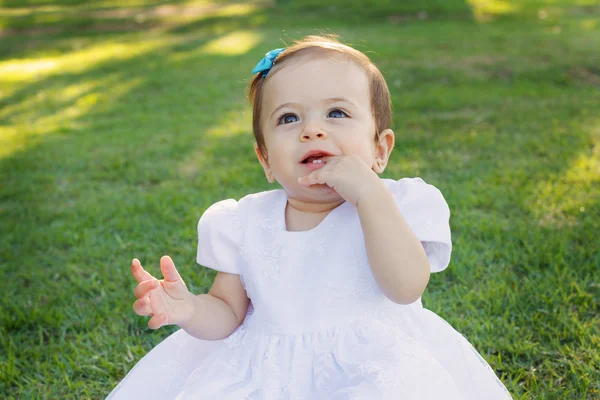 Cute happy smiling little baby girl in white dress scratching first teeth — Stock Photo, Image