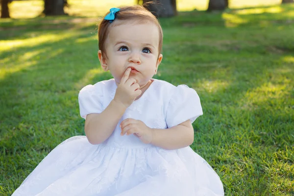 Cute happy little baby girl scratching first teeth in park — Stock Photo, Image