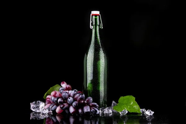 Botella de vino con uva roja — Foto de Stock