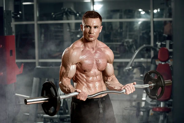 Young adult bodybuilder doing weight lifting in gym — Stock Photo, Image